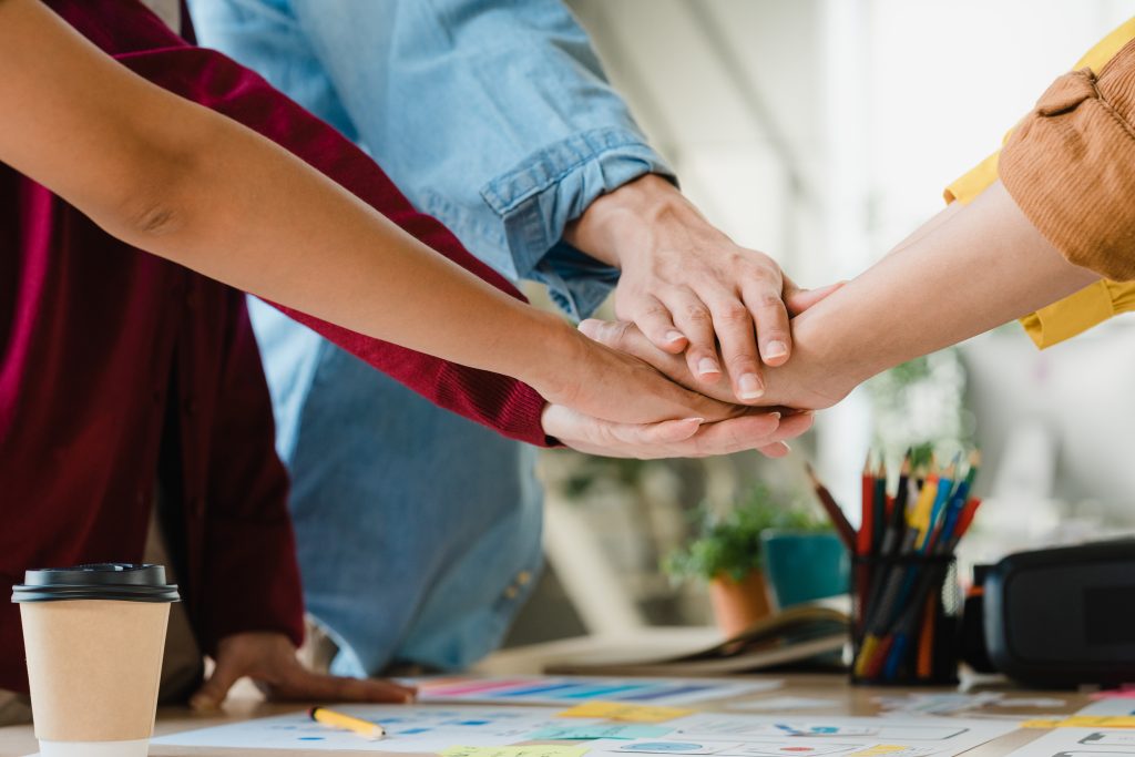 Grupo de personas juntando mano sobre el escritorio